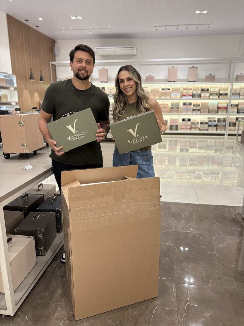 Equipe Vertenza segurando duas maletas verdes da marca