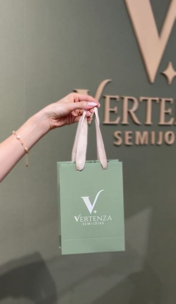 Sacola verde Vertenza em frente ao letreiro da marca